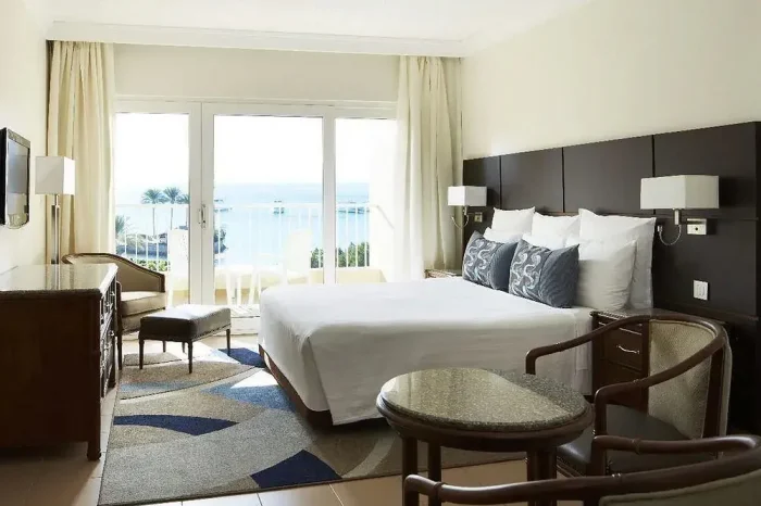 pokój-w-hotelu-lotus-bay-z-łóżkiem-komodą-i-balkonem