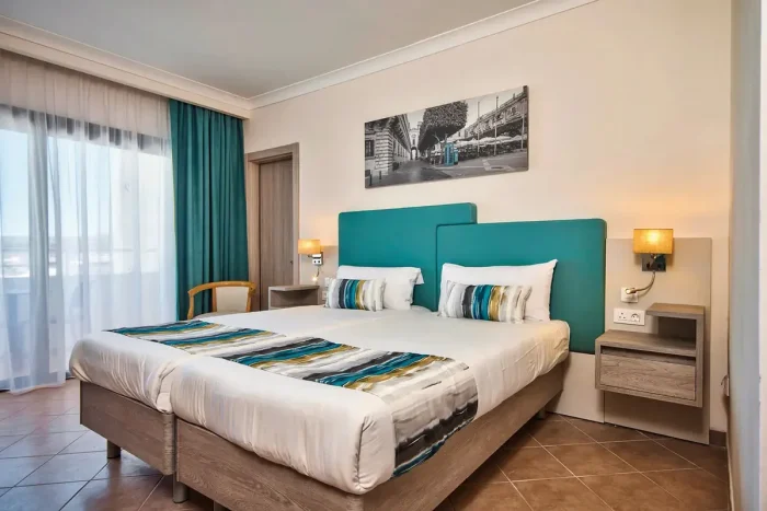 pokój-z-łóżkiem-obrazem-i-szafkami-w-hotelu-labranda-riviera-resort-spa