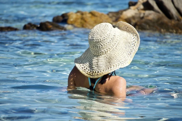 kobieta w kapeluszu zanurzona w wodzie